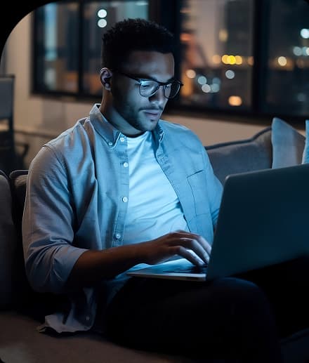 Profissional trabalhando em um notebook à noite